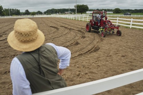 MK Bashar, right, test drives an electric tractor as Ben Phillips, left, watches Tuesday, Aug. 19, 2025, during a demonstration in East Lansing, Mich. (AP Photo/Joshua A. Bickel)