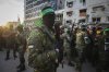 FILE - Fighters from the Qassam Brigades, the military wing of Hamas, control the crowd while Red Cross collect Israeli hostages to be released under a ceasefire agreement between Israel and Hamas, in Gaza City, Jan. 19, 2025. (AP Photo/Abed Hajjar, File)