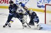 Jets goaltender Connor Hellebuyck (37) makes a save on St. Louis Blues captain Brayden Schenn (10) as Neal Pionk (4) defends during first period of an NHL playoff game in Winnipeg on Monday, April 21, 2025. THE CANADIAN PRESS/Fred Greenslade