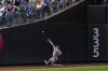 Washington Nationals outfielder Daylen Lile attempts to catch a fly ball by New York Mets' Cedric Mullins during the third inning of a baseball game against the New York Mets, Sunday, Sept. 21, 2025, in New York. (AP Photo/Yuki Iwamura)