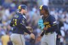Milwaukee Brewers relief pitcher Abner Uribe, right, celebrates with teammate catcher Danny Jansen after the Brewers defeated the San Diego Padres 3-1 in a baseball game Wednesday, Sept. 24, 2025, in San Diego. (AP Photo/Gregory Bull)
