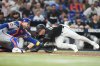 Miami Marlins' Troy Johnston, right, beats the throw to New York Mets catcher Luis Torrens, left, to score on a RBI triple hit by Heriberto Hernandez during the of a baseball game, Friday, Sept. 26, 2025, in Miami. (AP Photo/Lynne Sladky)