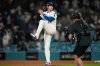 Los Angeles Dodgers' Shohei Ohtani makes a pitching motion on the mound after a win over the Cincinnati Reds in Game 1 of the National League Wild Card baseball playoff series Tuesday, Sept. 30, 2025, in Los Angeles. (AP Photo/Mark J. Terrill)