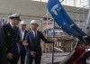 Prime Minister Mark Carney, right and Thyssenkrupp Marine Systems CEO Oliver Burkhardt, centre speak with Captain Jeremy in front of a 212A class submarine under maintenance as they tour the submarine building facility in Kiel, Germany on Tuesday, Aug. 26, 2025. THE CANADIAN PRESS/Christinne Muschi