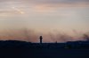 The ATC tower is seen while smoke rises from the crash site of UPS Flight 2796 near Louisville Muhammad Ali International Airport on Wednesday, Nov. 5, 2025, in Louisville, Ky. (AP Photo/Jon Cherry)