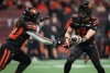 B.C. Lions quarterback Nathan Rourke, right, hands off to James Butler during the first half of a CFL football game against the Edmonton Elks, in Vancouver, on Friday, October 17, 2025. THE CANADIAN PRESS/Darryl Dyck