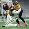 Edmonton Elks' Kurleigh Gittens Jr., front is unable to hold onto the ball on a reception as he's hit by B.C. Lions' Robert Carter Jr. during the second half of a CFL football game, in Vancouver, on Friday, Oct. 17, 2025. THE CANADIAN PRESS/Darryl Dyck