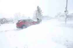 Kirby Oryniak and his boss work to get his vehicle out of a snow drift on Victoria Ave. east near Redonda in Transcona Thursday morning. He was on his way to work at 7:30 a.m. and didn’t get out of the drift until five hours later.  (Ruth Bonneville / Free Press)