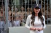 As prisoners stand looking out from a cell, Homeland Security Secretary Kristi Noem speaks during a tour of the Terrorist Confinement Center in Tecoluca, El Salvador, March 26, 2025. (AP Photo/Alex Brandon, File)