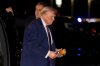 President Donald Trump holds a cell phone with a call to Nvidia CEO Jensen Huang as he departs on Air Force One at Rocky Mount-Wilson Regional Airport, Friday, Dec. 19, 2025, in Elm City, N.C. (AP Photo/Alex Brandon)
