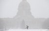 A worker blows snow in front of the Alberta Legislature during a heavy snowfall in Edmonton on Wednesday, Dec. 17, 2025. THE CANADIAN PRESS/Jason Franson