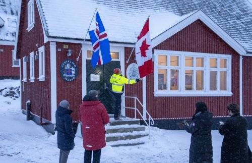 Flags are checked and temporarily raised before the opening of the Canadian consulate in Nuuk, Greenland, on Thursday, Feb. 5, 2026. THE CANADIAN PRESS/Christinne Muschi