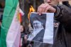 A man burns a photo of Iran's Supreme Leader Ayatollah Ali Khamenei during a protest at the Iranian Consulate in Milan, Italy, Monday, Jan. 12, 2026. (Claudio Furlan/LaPresse via AP)