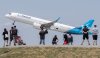People look on as an Air Transat plane takes off in Montreal on Sunday, June 11, 2023. THE CANADIAN PRESS/Graham Hughes