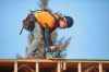 A construction worker at the Apollo Heights Phase 2 construction site does a little trimming with an electric saw while working at the top of one of the structures on site on a sunny and warm Thursday afternoon. The site, owned by Keller Developments, is part of a $47-million project that will add 165 rental units to Brandon’s housing stock. (Matt Goerzen/The Brandon Sun)