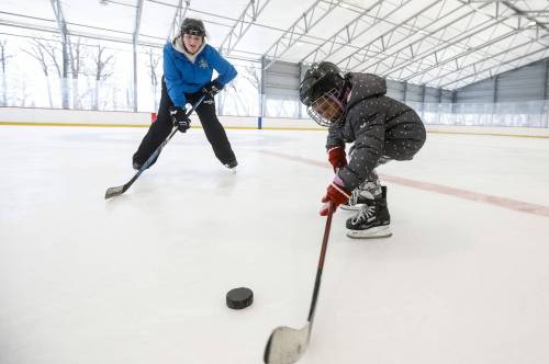 JOHN WOODS / FREE PRESS
                                Sam Taylor, activity leader, helps young immigrants to Winnipeg during a day out skating at Camp Manitou in Headingley Sunday, February 8, 2026. reporter: Maggie