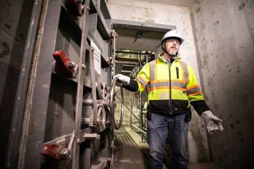 MIKAELA MACKENZIE / FREE PRESS
                                Deputy project director Rob Black demonstrates the submarine doors at the new pump station at the North End wastewater treatment plant on Wednesday.