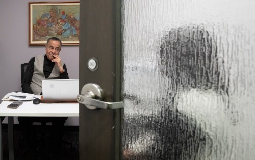 Frantz André, left, spokesperson for Comite d'action des persons sans statut (CAPSS), speaks to a Haitian migrant, who did not want to be identified and who recently crossed the border from the United States, in his offices in Montreal on Wednesday, Feb. 4, 2026. THE CANADIAN PRESS/Christinne Muschi