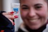 A woman shows a pin she is looking to trade at the 2026 Winter Olympics, in Cortina d'Ampezzo, Italy, Wednesday, Feb. 11, 2026. (AP Photo/Robert F. Bukaty)