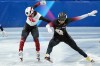 Canada's William Dandjinou, left, and Latvia's Roberts Kruzbergs race to the finish line in the men's 1,000 metre short track speedskating finals at the 2026 Winter Olympics, in Milan, on Thursday, February 12, 2026. THE CANADIAN PRESS/Darryl Dyck