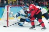 Canada forward Nathan MacKinnon (29) and Finland goaltender Juuse Saros (74) eye the loose puck during third period men's Olympic semifinal hockey action at the 2026 Milan Cortina Winter Olympics in Milan, Italy on Friday, Feb. 20, 2026. THE CANADIAN PRESS/Nathan Denette