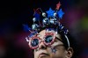 A fan waits for the short track speed skating men's 500m to start at the 2026 Winter Olympics, in Milan, Italy, Wednesday, Feb. 18, 2026. (AP Photo/Ashley Landis)