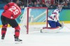 American goaltender Connor Hellebuyck (37) looks on as Canadian forward Nathan MacKinnon's shot misses the open net during third period of the men's gold-medal hockey game at the Winter Olympics in Milan on Sunday, Feb. 22, 2026.