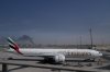 ADDS CAUSE OF BLACK SMOKE IN THE BACKGROUND.- A plume of smoke caused by an Iranian strike is seen in the background an an Emirates plane is parked at the Dubai International Airport after its closure in Dubai, United Arab Emirates, Sunday, March 1, 2026. (AP Photo/Altaf Qadri)