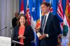 British Columbia Premier David Eby, right, gifts a bottle of B.C. wine to Alberta Premier Danielle Smith while speaking to reporters at the Council of the Federation meetings in Halifax on Tuesday, July 16, 2024. THE CANADIAN PRESS/Darren Calabrese