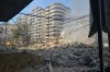 Smoke rises above debris at the site of a building hit in an Israeli airstrike on Dahiyeh, a southern suburb of Beirut, Lebanon, Tuesday, March 3, 2026. (AP Photo/Hassan Ammar)