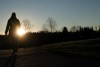 The sun rises over the mountain as a woman takes a walk in Vancouver, Monday, Jan. 18, 2021. THE CANADIAN PRESS/Jonathan Hayward
