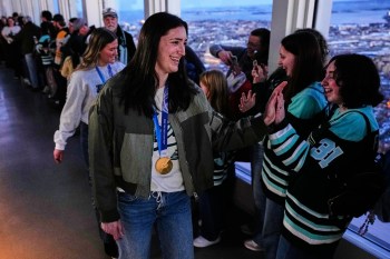 United States women's gold medal hockey players Megan Keller, center, and Haley Winn, rear left, are greeted during a gathering with fans, Monday, March 2, 2026, in Boston. (AP Photo/Charles Krupa)